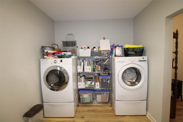 clothes washing area featuring wood finished floors, laundry area, and washer / dryer