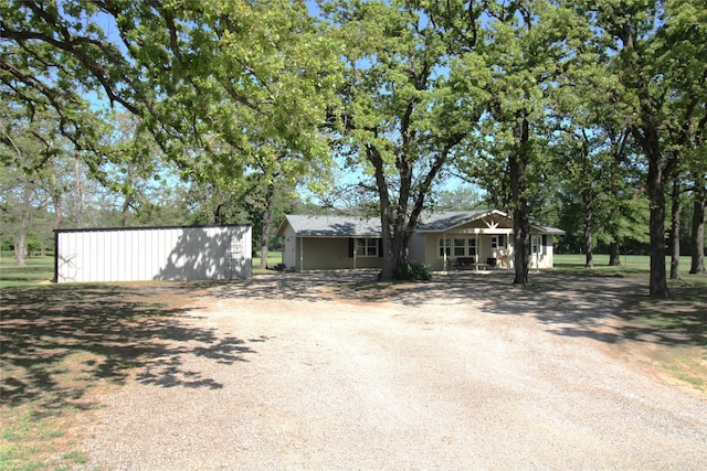 view of front of house with driveway and an outbuilding