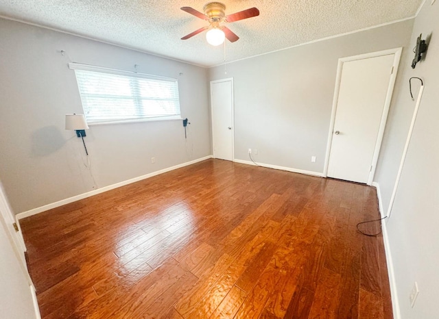 unfurnished room featuring ceiling fan, baseboards, wood finished floors, and a textured ceiling