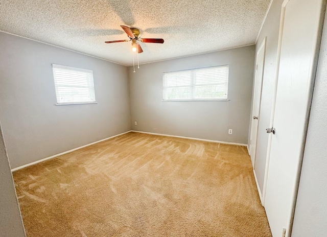 unfurnished room with light carpet, a textured ceiling, ceiling fan, and a healthy amount of sunlight