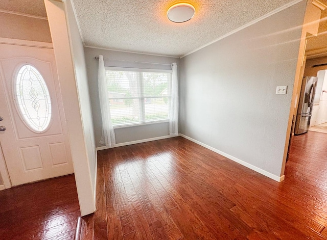 foyer with baseboards, ornamental molding, wood finished floors, and a textured ceiling
