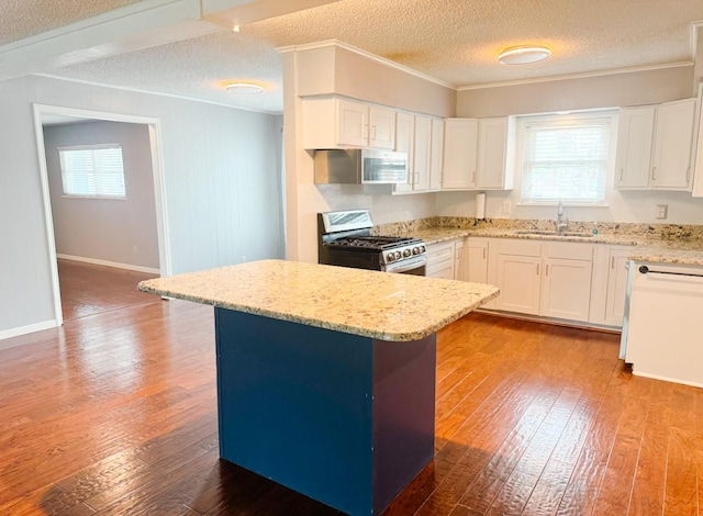 kitchen featuring wood-type flooring, light stone countertops, stainless steel appliances, and a textured ceiling