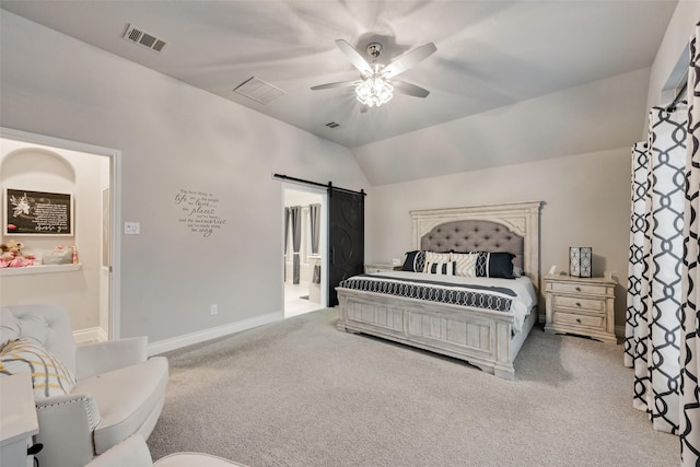 bedroom with lofted ceiling, visible vents, carpet floors, and a barn door