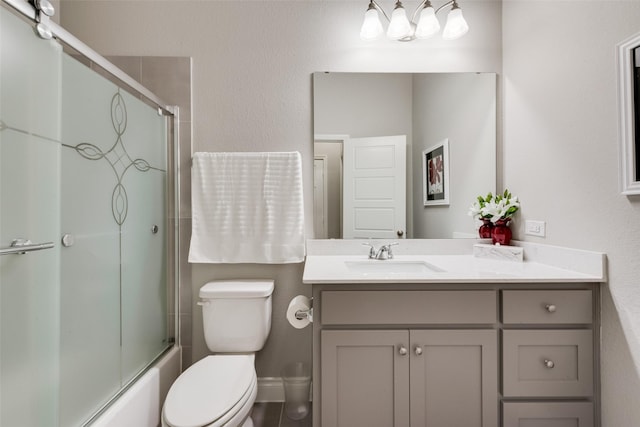 bathroom with bath / shower combo with glass door, toilet, and vanity