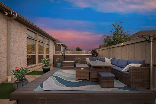 patio terrace at dusk with an outdoor hangout area and a fenced backyard