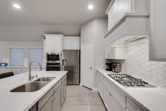 kitchen featuring appliances with stainless steel finishes, a sink, and light countertops