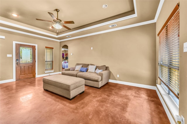 1114 N Elm St, Weatherford, TX 76086 - living area featuring finished concrete flooring, a tray ceiling, arched walkways, ceiling fan, and baseboards