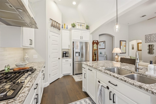3204 Discovery Dr, Little Elm, TX 75068 - kitchen featuring stainless steel appliances, under cabinet range hood, a sink, arched walkways, and dark wood finished floors