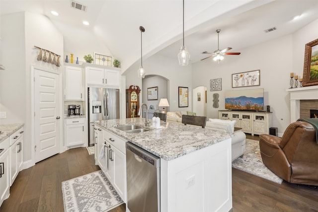 3204 Discovery Dr, Little Elm, TX 75068 - kitchen with stainless steel appliances, open floor plan, a sink, ceiling fan, and arched walkways
