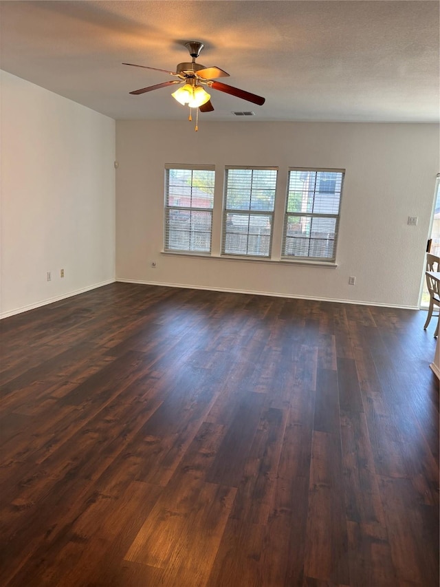 empty room featuring a ceiling fan, baseboards, and dark wood-style flooring