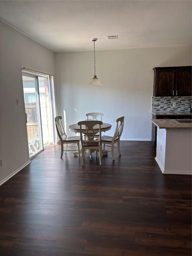 dining area featuring dark wood finished floors, baseboards, and visible vents