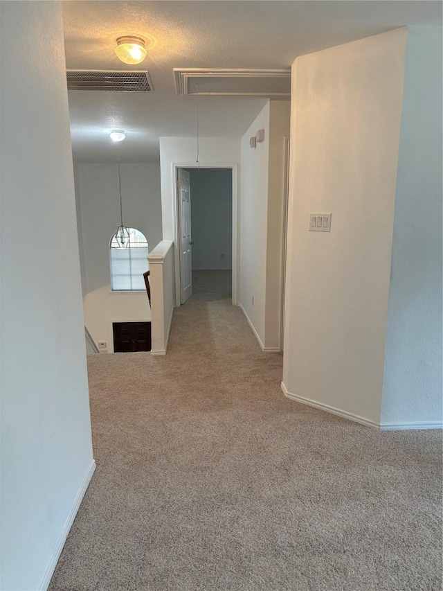 hall featuring attic access, visible vents, carpet, and an upstairs landing