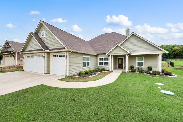 view of front of home featuring a chimney, a garage, driveway, roof with shingles, and a front yard