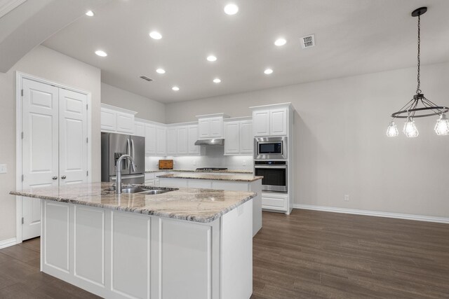 kitchen with a large island with sink, baseboards, dark wood-style floors, and appliances with stainless steel finishes