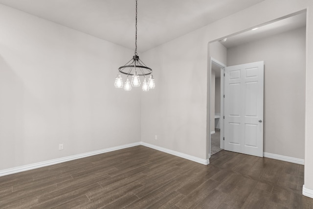 unfurnished dining area with an inviting chandelier, dark wood-style floors, and baseboards