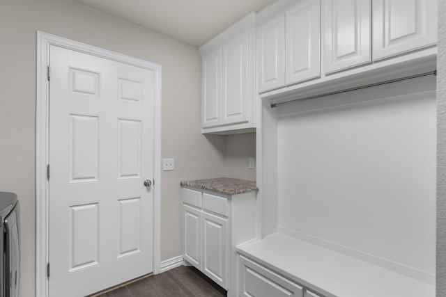 mudroom featuring baseboards and dark wood-type flooring