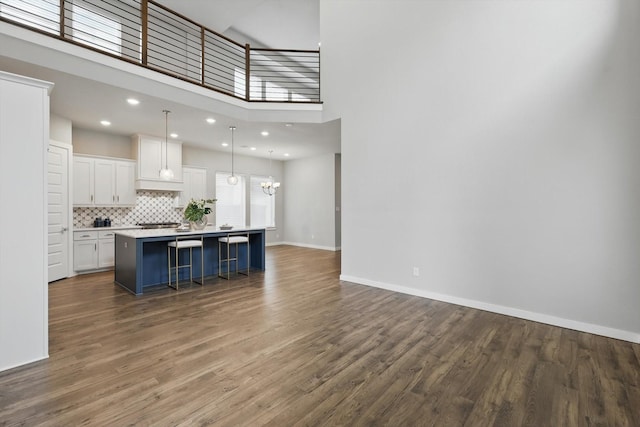 kitchen with wood finished floors, white cabinetry, tasteful backsplash, and light countertops