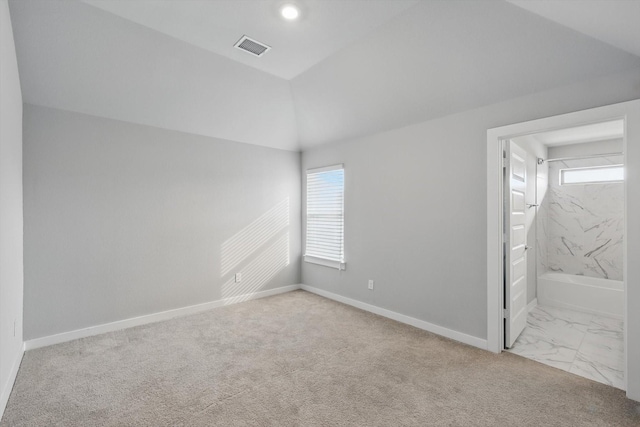 unfurnished bedroom featuring lofted ceiling, connected bathroom, visible vents, baseboards, and marble finish floor