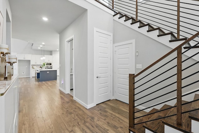 interior space featuring recessed lighting, stairway, wood finished floors, and baseboards