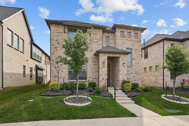 view of front facade with brick siding and a front yard