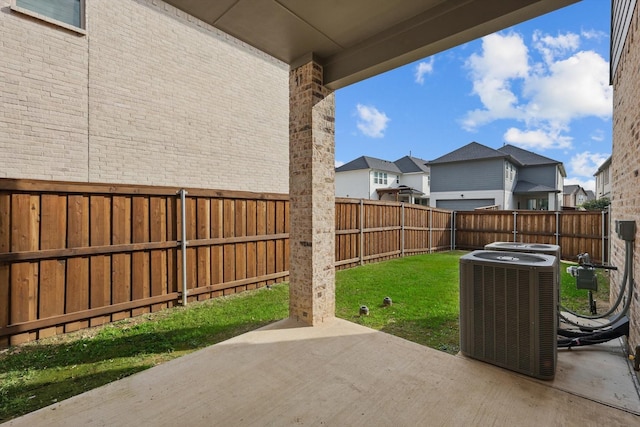 view of patio / terrace with a fenced backyard, central AC unit, and a residential view