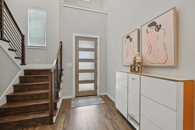 entryway featuring dark wood-type flooring, stairway, and baseboards