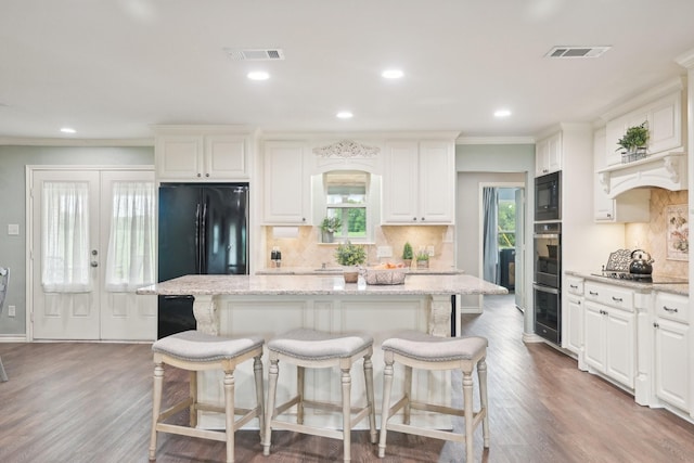 108 N Westlake Dr, Leonard, TX 75452 - kitchen with black appliances, a kitchen island, a kitchen bar, backsplash, and crown molding
