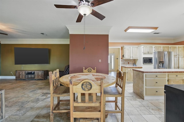 dining area featuring ceiling fan, baseboards, ornamental molding, and visible vents