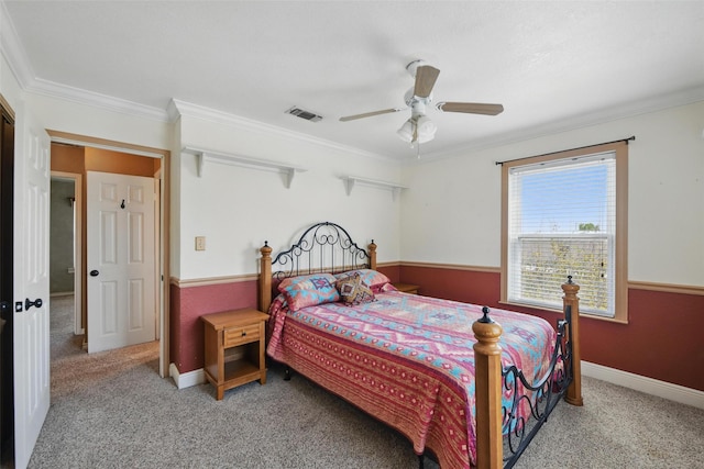 carpeted bedroom featuring baseboards, visible vents, ceiling fan, and crown molding