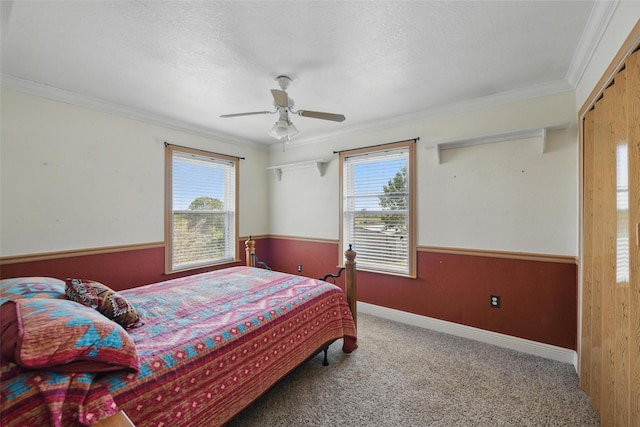 carpeted bedroom with ceiling fan, ornamental molding, and multiple windows