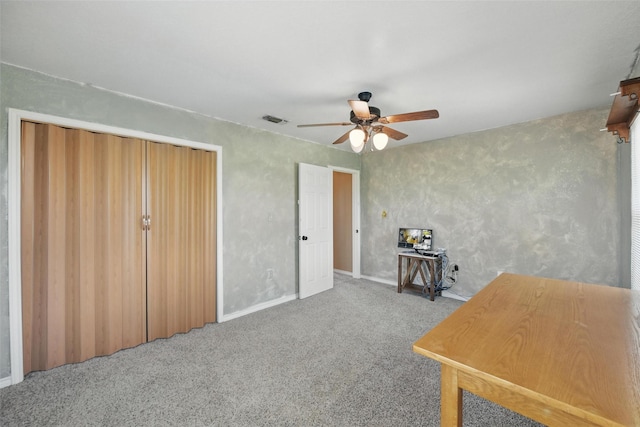 office area featuring carpet flooring, visible vents, a ceiling fan, and baseboards