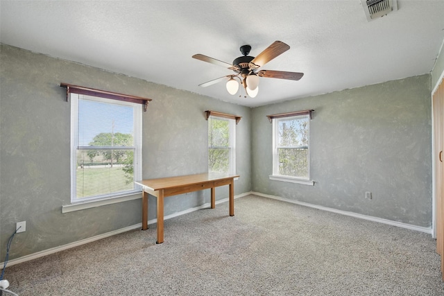unfurnished office with baseboards, visible vents, carpet, and ceiling fan