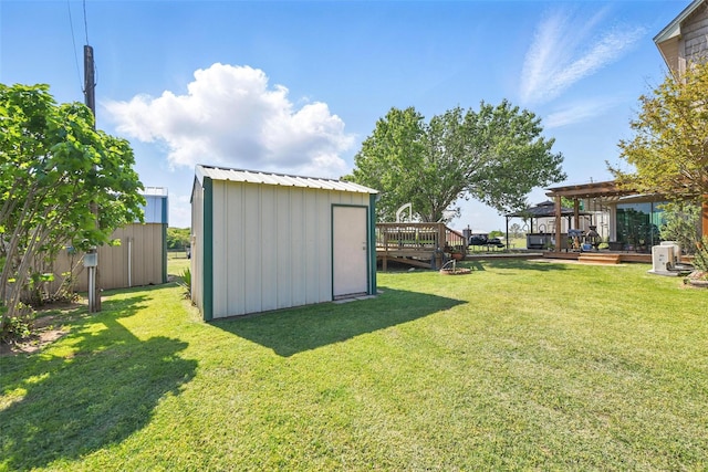 view of yard with an outdoor structure, a deck, and a storage shed