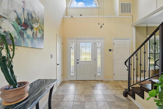 entryway featuring plenty of natural light, visible vents, and a towering ceiling