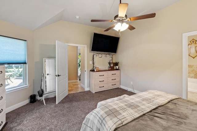 bedroom with vaulted ceiling, carpet flooring, connected bathroom, and ceiling fan