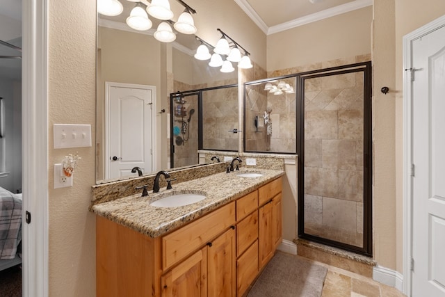 bathroom with a shower stall, crown molding, a sink, and double vanity