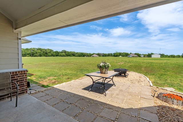 view of patio featuring a rural view and an outdoor fire pit