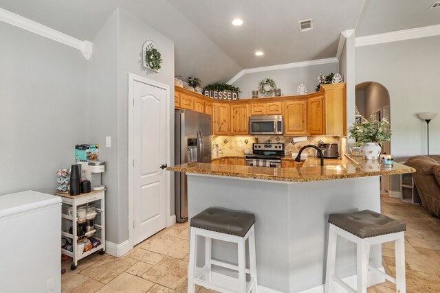 kitchen featuring a peninsula, crown molding, visible vents, and appliances with stainless steel finishes