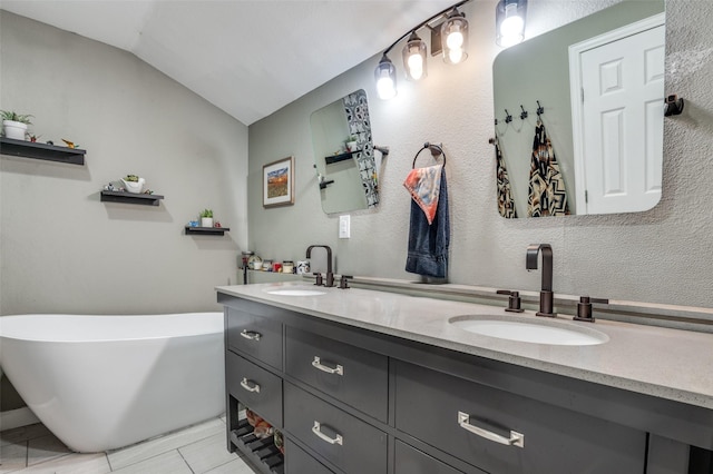 411 E Ross St, Waxahachie, TX 75165 - full bathroom featuring vaulted ceiling, double vanity, a freestanding bath, and tile patterned floors