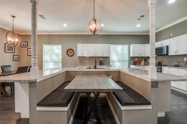 411 E Ross St, Waxahachie, TX 75165 - kitchen with a chandelier, a sink, a breakfast bar area, dark wood finished floors, and ornamental molding