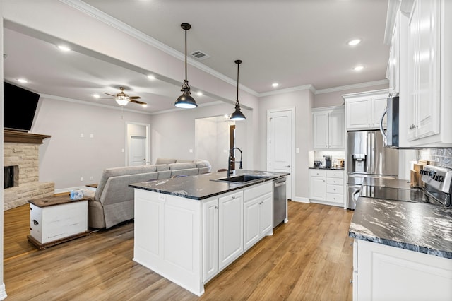 2210 County Road 1104, Cleburne, TX 76031 - kitchen featuring a sink, open floor plan, light wood-type flooring, ceiling fan, and appliances with stainless steel finishes