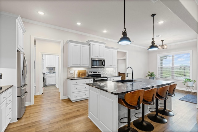 2210 County Road 1104, Cleburne, TX 76031 - kitchen with a kitchen breakfast bar, stainless steel appliances, dark countertops, a sink, and light wood-type flooring