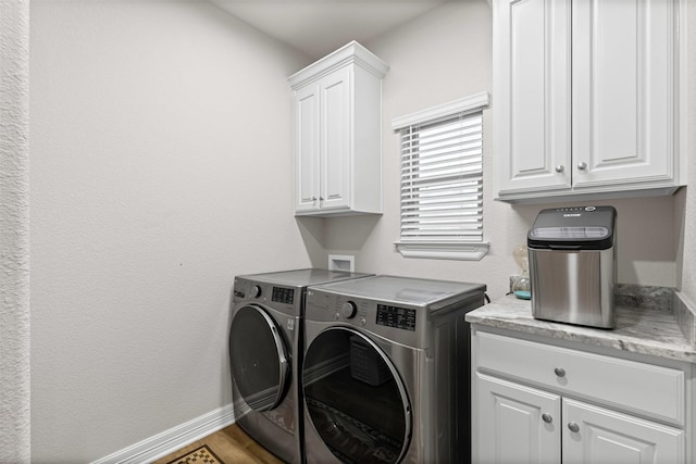 2210 County Road 1104, Cleburne, TX 76031 - laundry room featuring washing machine and dryer, wood finished floors, baseboards, and cabinet space