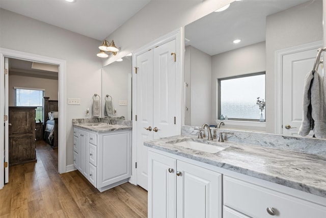 2210 County Road 1104, Cleburne, TX 76031 - ensuite bathroom featuring two vanities, ensuite bathroom, wood finished floors, and a sink
