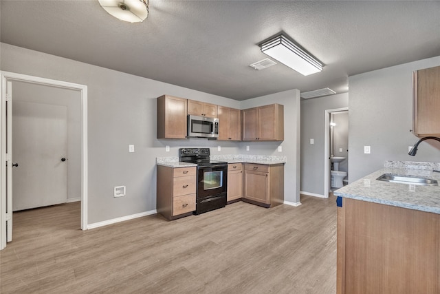 kitchen with light wood finished floors, visible vents, a sink, stainless steel microwave, and black electric range oven