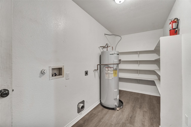 clothes washing area with hookup for a washing machine, wood finished floors, hookup for an electric dryer, water heater, and laundry area