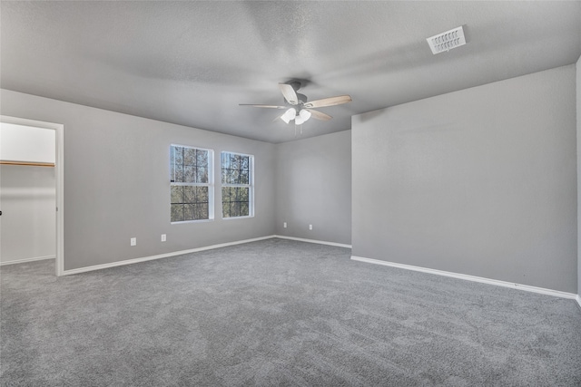 unfurnished bedroom featuring a ceiling fan, a spacious closet, carpet, baseboards, and visible vents