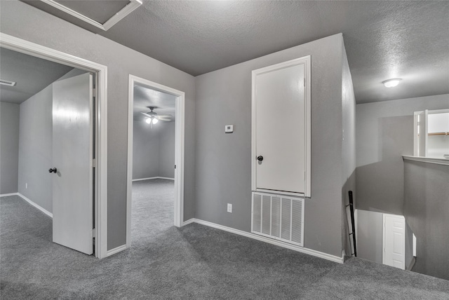 interior space featuring baseboards, a textured ceiling, and visible vents