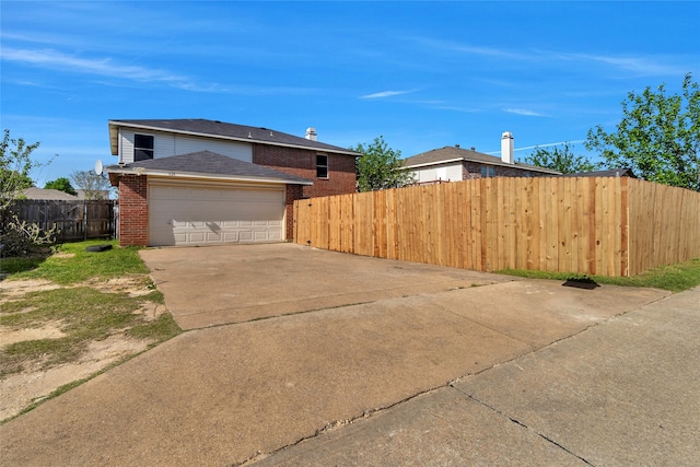 view of property exterior featuring brick siding, an attached garage, driveway, and fence