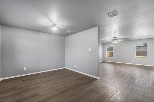 unfurnished room featuring ceiling fan, baseboards, dark wood-style flooring, and visible vents
